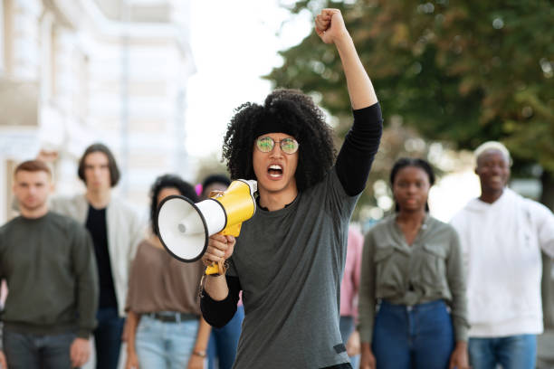 istock Guy with megaphone leading group of protestors, copy space 1312601048