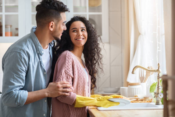 istock Loving Arab Husband Embracing Wife From The Back While She Washing Dishes 1312601349