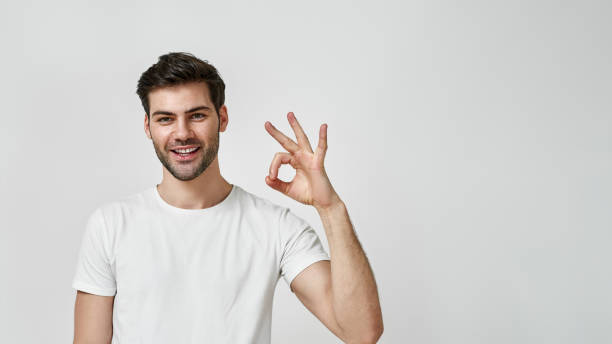 istock Young man in white t-shirt showing okay gesture 1312601432