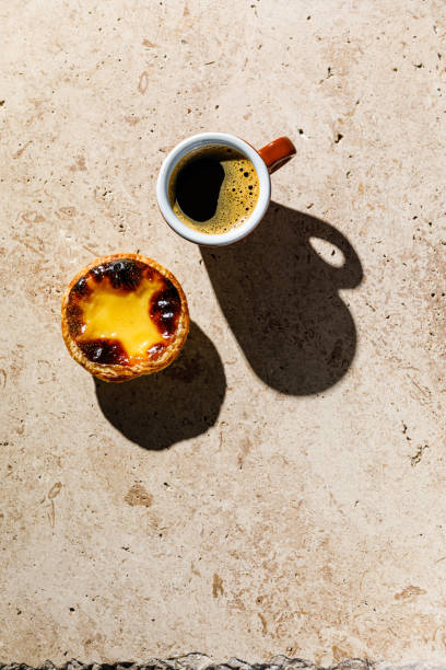 café e pastel de nata fresco assado creme de ovo português torta no fundo de pedra bege - pastel de belem - fotografias e filmes do acervo