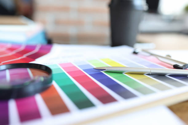 istock Color palette with pen and magnifying glass is on table 1312601655