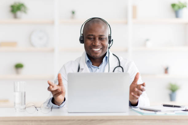 istock Highly qualified african american doctor consultating patients distantly using laptop computer and explaining diagnosis 1312604413
