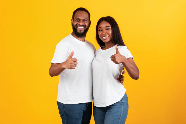 istock Happy afro couple gesturing thumbs up, hugging and smiling 1312604817