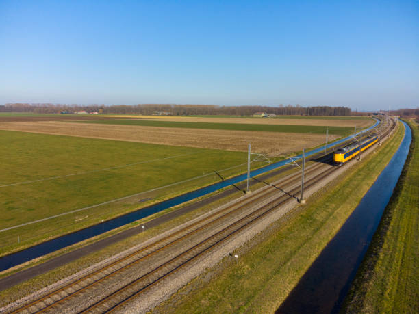 trein van de nederlandse spoorwegen, nederlandse spoorwegen die op een spoorwegspoor in het land drijven - ns stockfoto's en -beelden