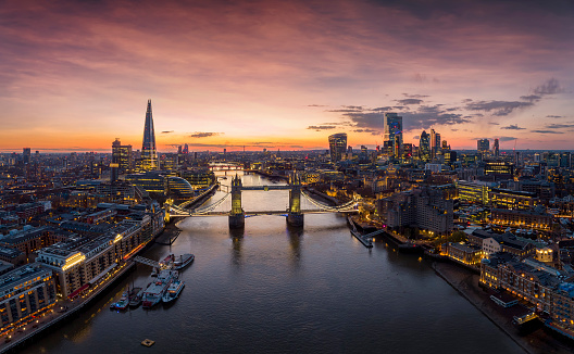 Panoramic aerial view to the illuminated skyline of London, United Kingdom, during a colorful evening