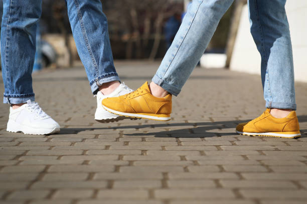 istock People greeting each other by bumping feet instead of handshake outdoors, closeup 1312607804