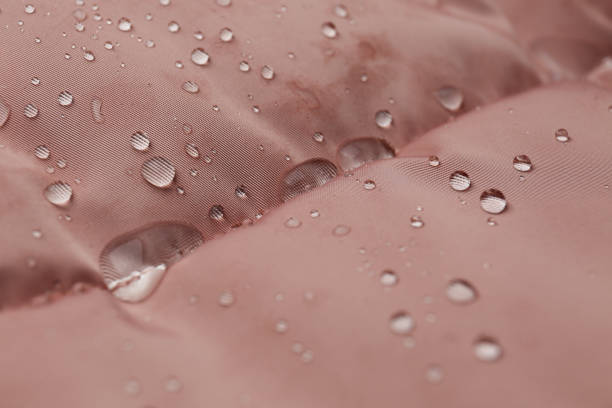 Pink waterproof fabric with water drops as background, closeup Pink waterproof fabric with water drops as background, closeup water repellent stock pictures, royalty-free photos & images