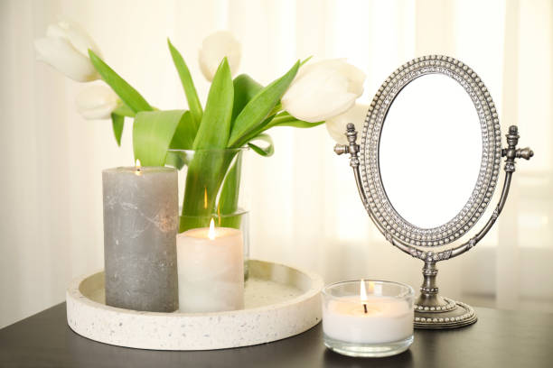 istock Burning candles, mirror and flowers on black table indoors 1312608004