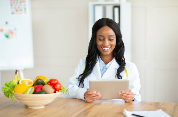 istock African American nutritionist working with tablet computer, giving online consultation at medical office, copy space 1312608008