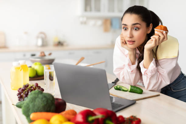 istock Surprised shocked woman standing in kitchen, using laptop 1312608073