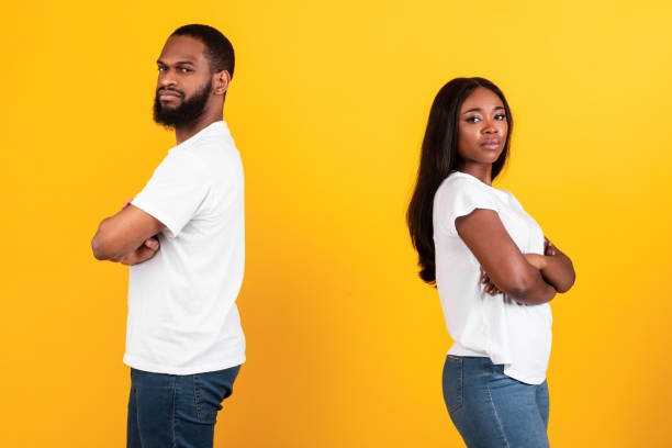 istock Afro couple standing back to back, yellow studio wall 1312608214