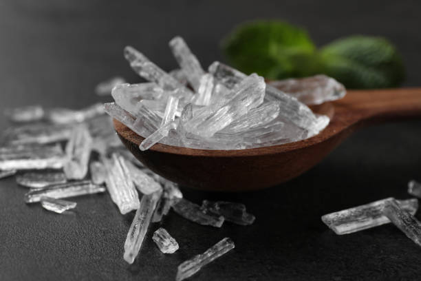 istock Menthol crystals in spoon on grey background, closeup 1312609190