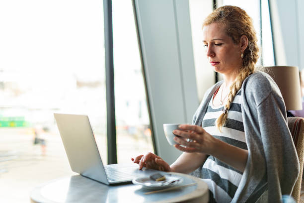 istock Woman using laptop in coffee bar 1312609503