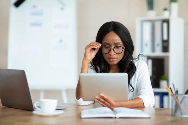 istock Serious female entrepreneur working on tablet pc at office, participating in webinar or online conference at office 1312609726