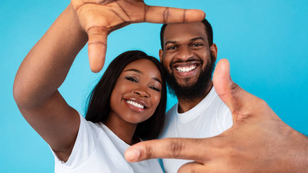 istock Happy black couple making picture frame with fingers 1312610741