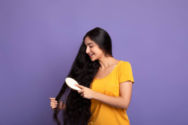 junge indische frau bürsten lange haare mit holzkamm - wooden mannequin stock-fotos und bilder
