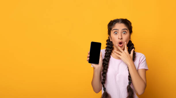 istock Surprised Indian woman showing blank smartphone screen 1312611356
