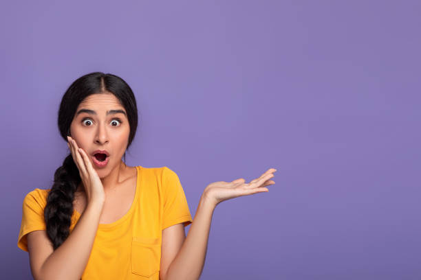 istock Surprised young indian woman showing copy space with palm 1312612500