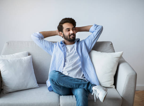istock Relaxed Arab Guy Leaning Back On Couch With Hands Behind Head 1312612623