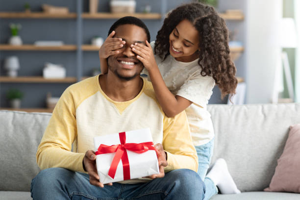 istock Cute little daughter giving present to her daddy 1312612755