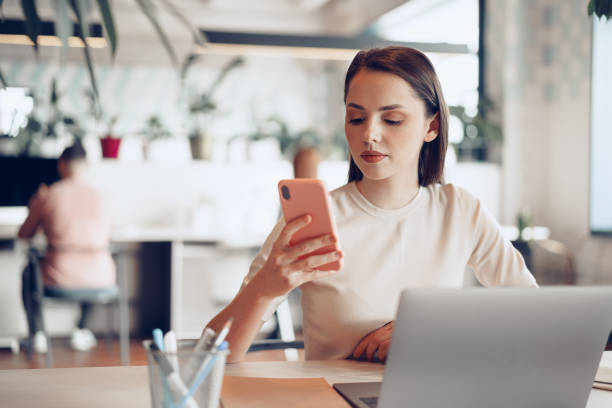 istock Young attractive businesswoman using her smartphone in office 1312613920