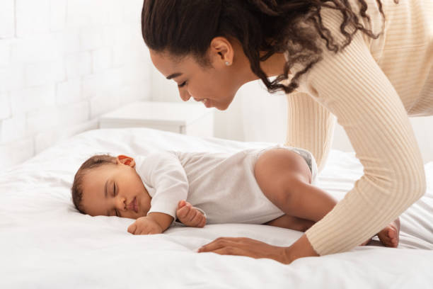 istock Happy Black Mother Looking At Her Sleeping Baby Boy Indoor 1312614096