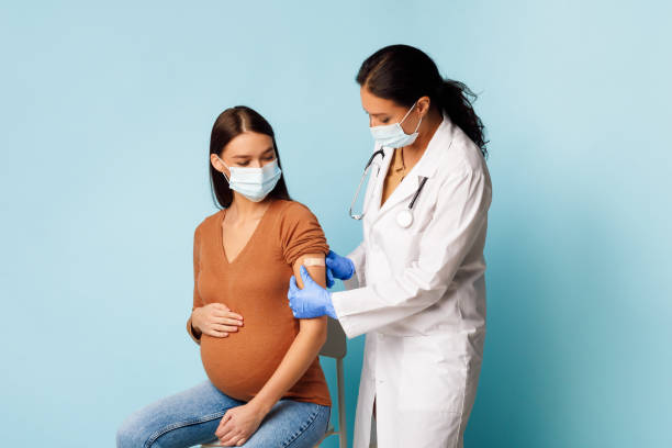 간호사 예방 접종 임신 한 여성 환자에 대한 covid-19 위에 블루 배경 - injecting nurse doctor women 뉴스 사진 이미지