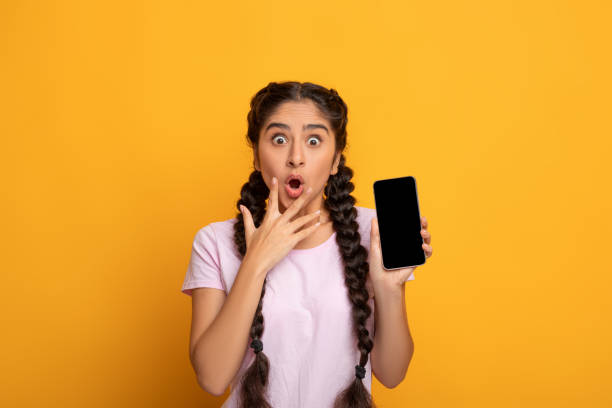 istock Surprised Indian woman showing blank smartphone screen 1312615112