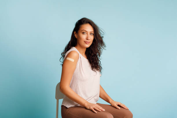 istock Vaccinated Woman Showing Arm Sitting With Rolled Up Sleeves, Studio 1312616496