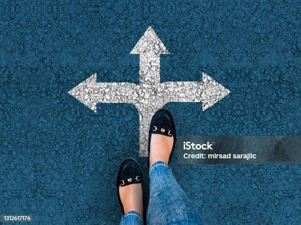 Woman Legs In Shoes Standing On Road With Three Direction Arrow Stock Photo - Download Image Now