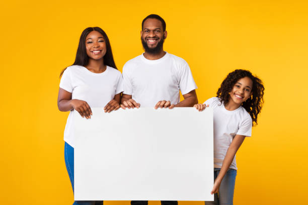 istock Black family holding blank white advertising billboard at studio 1312617734