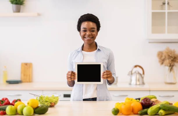 istock Cheerful Black Lady Showing Empty Tablet Screen Posing In Kitchen 1312617893