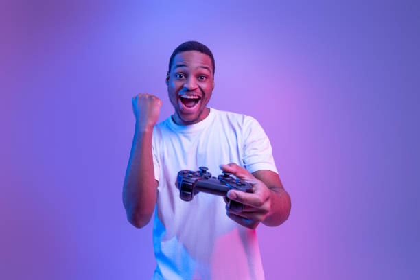 istock Video Gaming Concept. Euphoric African American Guy With Joystick Celebrating Game Win 1312618106