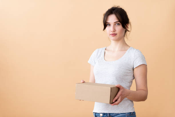 istock smiling blonde girl shows a box on the right side 1312618192