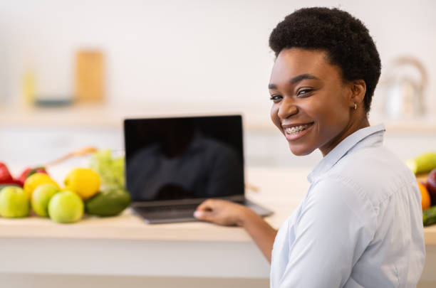 istock Black Lady At Laptop Posing Sitting In Modern Kitchen Indoor 1312618563