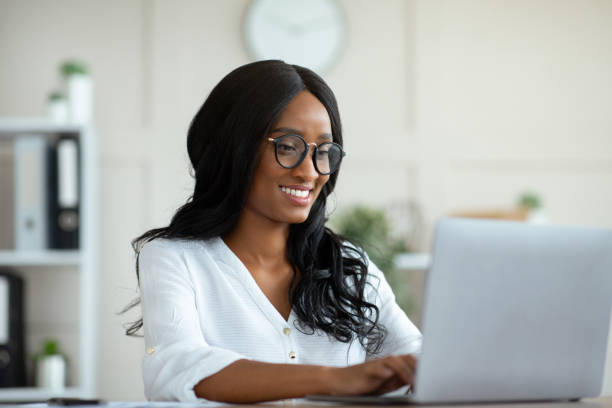 istock Happy female company worker using laptop pc and typing on keyboard at office 1312619841