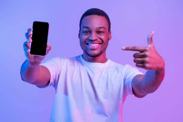 istock Mobile Offer. Joyful Black Man Pointing At Smartphone With Blank Screen 1312622273