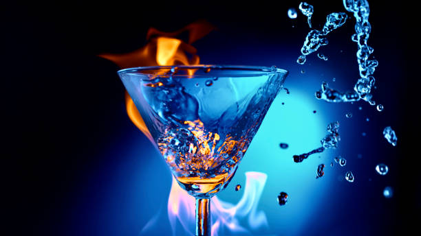 istock Water being splashed into martini glass against blue background 1312623556