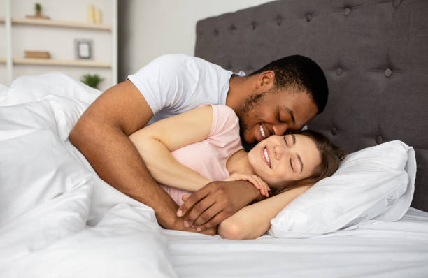 집에서 침대에서 껴안고, 서로를 껴안고, 아침에 깨어난 후 친밀한 전희를 하는 다인종 커플 - sexual activity black couple african descent 뉴스 사진 이미지