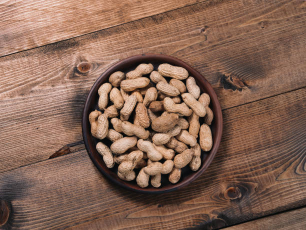 istock Freshly roasted peanuts on a clay plate on a wooden tabletop 1312627262
