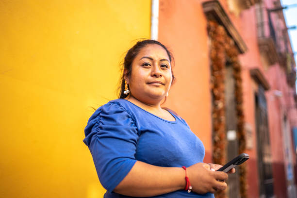 jeune femme à l’extérieur utilisant le smartphone - mexican ethnicity photos et images de collection