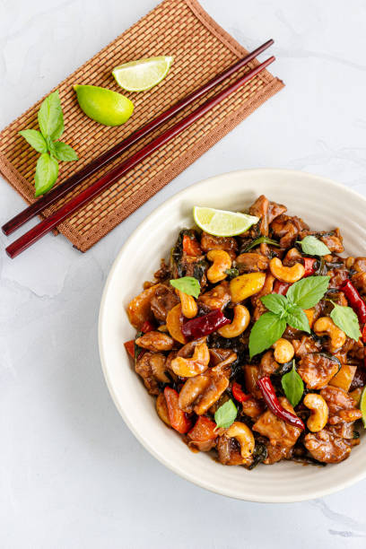 istock Stir-Fried Cashew Chicken in a Bowl Garnished with Fresh Thai Basil and Lemon 1312627791