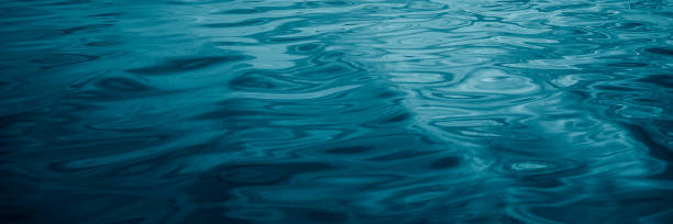 istock Abstract blue green background. Reflection of sunlight on a wavy water surface. Ripples. Beautiful teal background with copy space for design. 1312631445