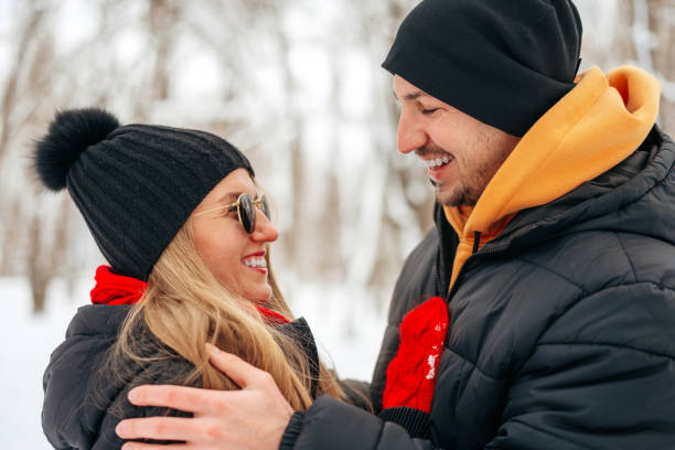 istock Happy couple hugging and smiling outdoors in snowy park 1312631454