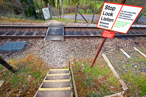 Pedestrian railway crossing near Tisbury, Wiltshire, England. Warning signs alert pedestrians to take care in crossing this active railway line near Tisbury, Wiltshire, England