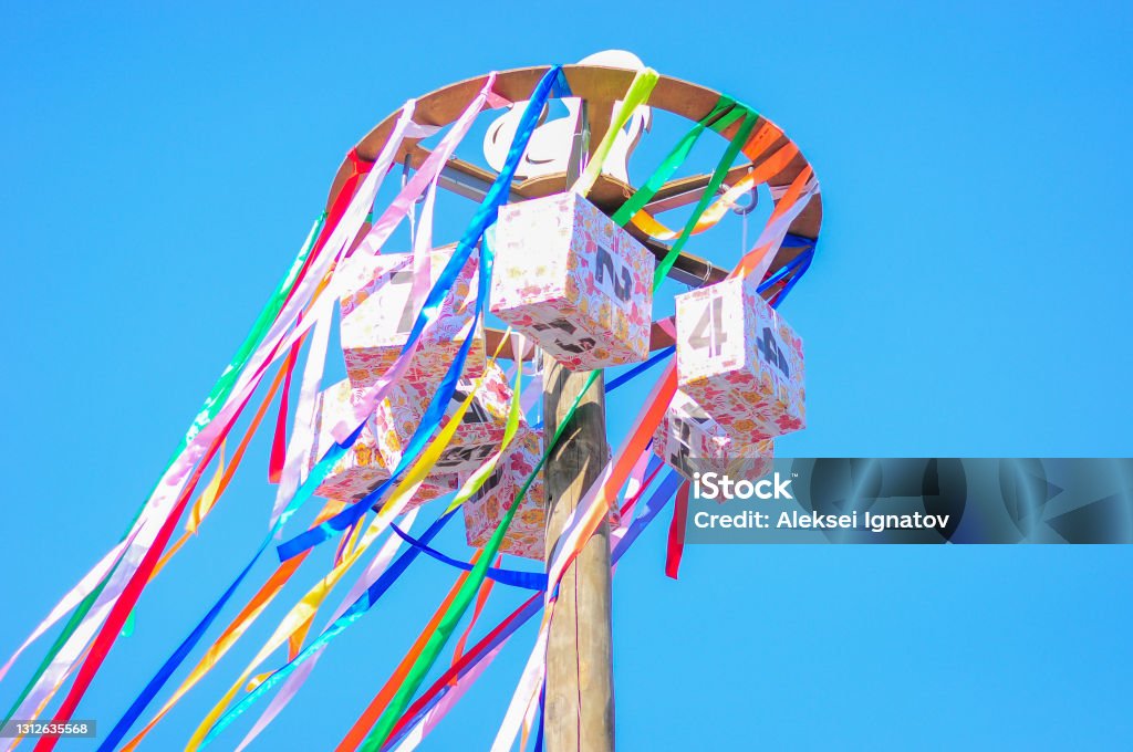 Maslenitsa. Competition for the agile. On a background of blue sky. Competition for the agile. Prizes are suspended from a high pillar. Maslenitsa. Maslenitsa Stock Photo