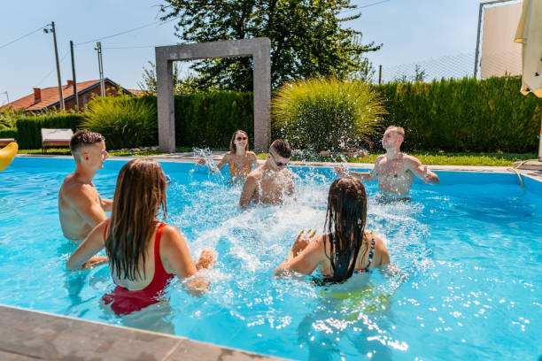 istock Friends sprinkle in swimming pool 1312635826