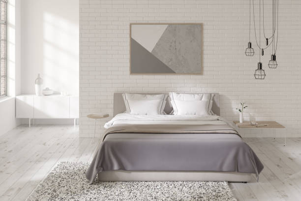 istock White bedroom with a horizontal poster on a brick wall, a double bed, a black modern chandelier, dressing tables, a carpet on a white wooden floor, a curbstone in the background. Front view. 1312638942