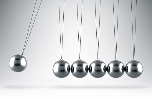 Balancing balls Newton's cradle hanging on gray background