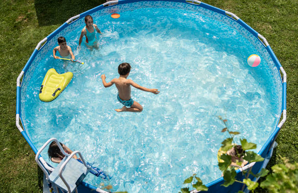 istock High view  of a boy jumping into a sparkling swimming pool 1312642939